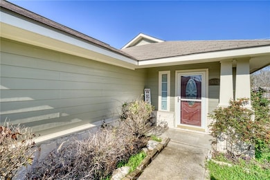 View of exterior entry featuring a shingled roof