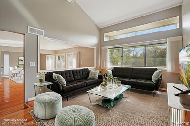 Living room featuring high vaulted ceiling, wood finished floors, and healthy amount of natural light