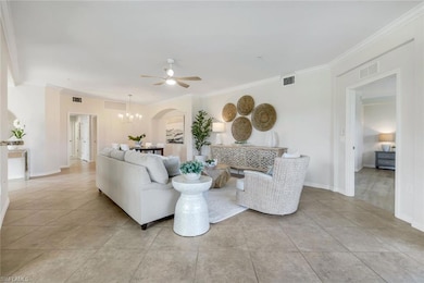 Living area with ceiling fan, a chandelier, ornamental molding, arched walkways, and baseboards