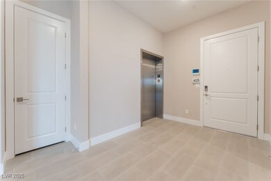 Entrance foyer featuring elevator, baseboards, and
