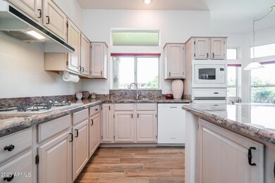 Kitchen has gas cooktop and granite tops