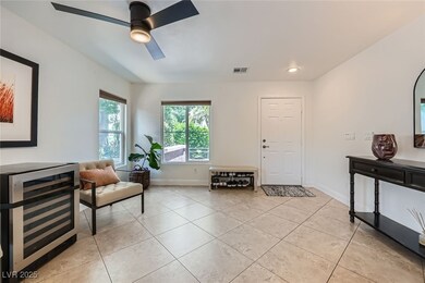 Sitting room featuring beverage cooler, light tile