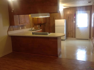 Kitchen featuring kitchen peninsula, a textured ce