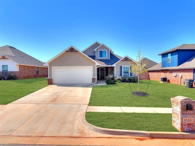 View of front of home featuring a front yard, an attached garage, concrete driveway, and central air condition unit