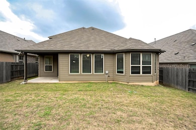Rear view of house with a fenced backyard, a yard