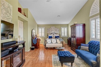 Bedroom featuring light wood-style floors, a ceiling fan, and high vaulted ceiling