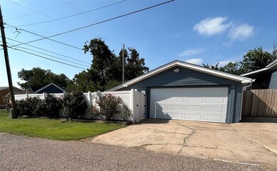 View of front facade featuring a garage, an outbui