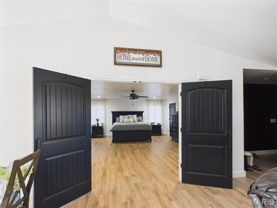 Bedroom featuring vaulted ceiling and light wood-type flooring