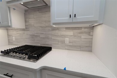 Kitchen featuring tasteful backsplash, white cabin