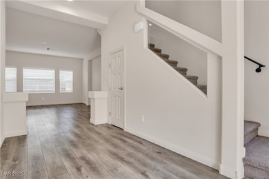 Stairway with wood finished floors and baseboards