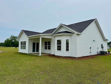 Back of property with a patio, a shingled roof, and a yard