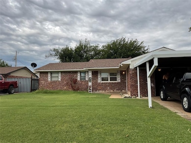 Ranch-style home featuring a carport and a front y