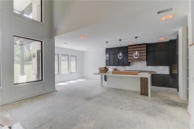 Kitchen featuring hanging light fixtures, concrete