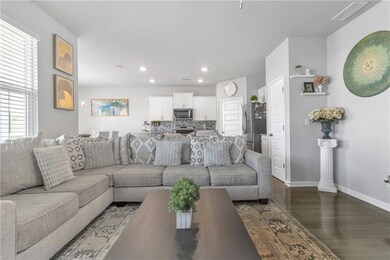 Living room with dark wood-style flooring, baseboards, and recessed lighting