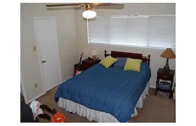 Bedroom with a ceiling fan and carpet