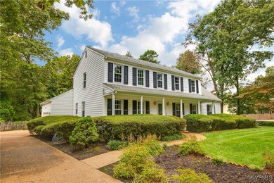 Colonial inspired home with a front lawn and cover