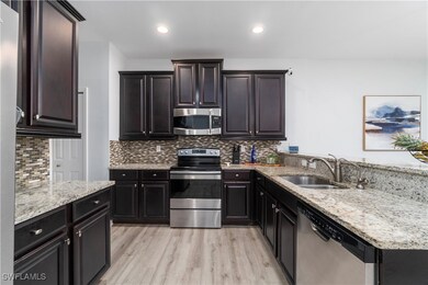 Kitchen with light stone countertops, sink, applia