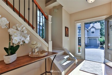 The entry has a beautiful staircase and railing, a nook for a decorative table and is sunny and light.