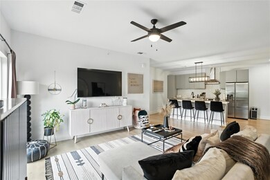 Living area with ceiling fan and light wood finis
