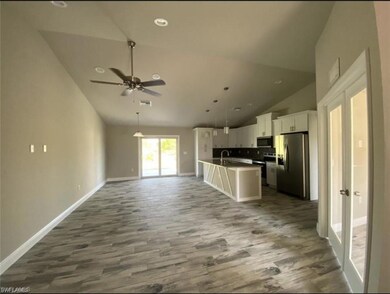 Kitchen featuring stainless steel appliances, open floor plan, dark wood finished floors, white cabinets, and recessed lighting