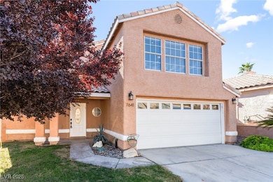 View of front facade with stucco siding, driveway, a tiled roof, and an attached garage