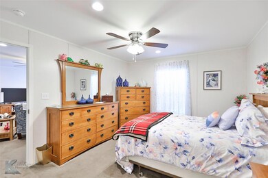 Carpeted bedroom featuring ceiling fan and crown m