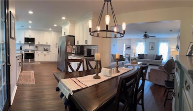 Living room featuring a ceiling fan, dark wood-type flooring, and a textured ceiling