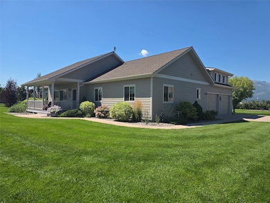 Front view of property with a yard, covered porch, a shingled roof, and concrete driveway