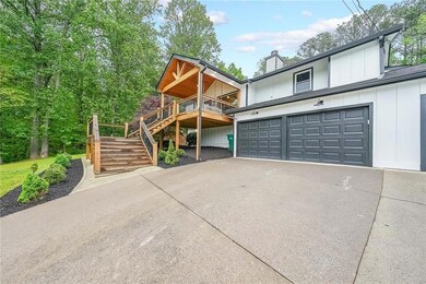 View of front of property with driveway, stairs, a chimney, board and batten siding, and a garage
