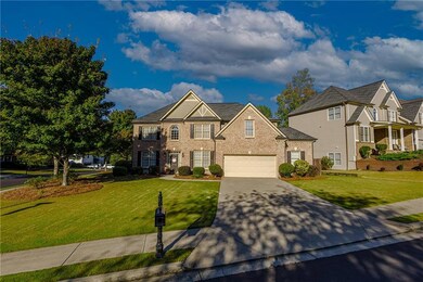 View of front of house featuring concrete driveway, a front lawn, and brick siding