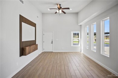 Foyer with baseboards, a high ceiling, light wood-style floors, and ceiling fan