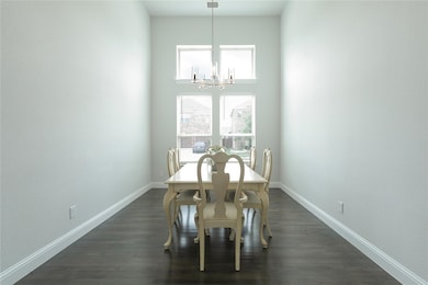 Dining space featuring an inviting chandelier, plenty of natural light, and dark hardwood / wood-style floors

