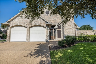 View of front of home featuring concrete driveway, brick siding, a garage, and a front yard