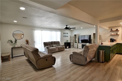 Living area with recessed lighting, light wood-style floors, ceiling fan, and a textured ceiling