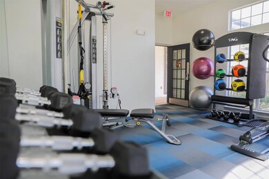 Exercise room featuring a towering ceiling and a w