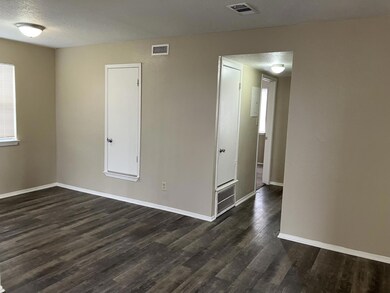 Spare room with baseboards, dark wood-type floori