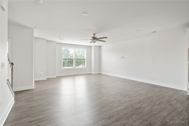 Empty room featuring ceiling fan and dark hardwood