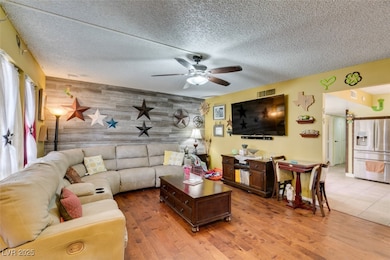 Living area featuring visible vents, ceiling fan,