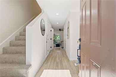 Corridor featuring stairway, light wood-style flooring, and recessed lighting