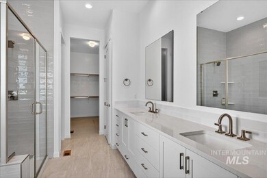 Bathroom featuring double vanity, a stall shower, a walk in closet, recessed lighting, and light tile patterned floors