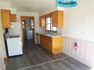 The kitchen has original cabinets and is open to t