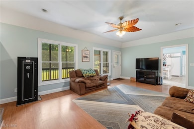 Living room featuring light wood finished floors, ceiling fan, and recessed lighting