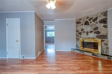 LIVING ROOM WITH DECORATIVE STONE FIREPLACE APPROX. 18'X14' WITH PARTIAL BATH LIGHT, BRIGHT, FRESHLY PAINTED, EASY TO MAINTAIN FLOORING,  CLEAN WHITE DOORS WITH CEILING LIGHT/FANS.