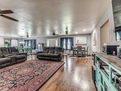 Living area with ceiling fan, wood finished floors