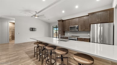 Kitchen with ceiling fan, vaulted ceiling, sink, a
