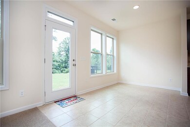 Entryway with healthy amount of natural light, tile patterned floors, and recessed lighting