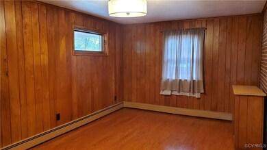 Unfurnished room featuring wood walls, light hardw