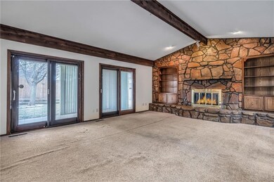 Spacious front room with vaulted ceiling, built in bookcases and gas fireplace.