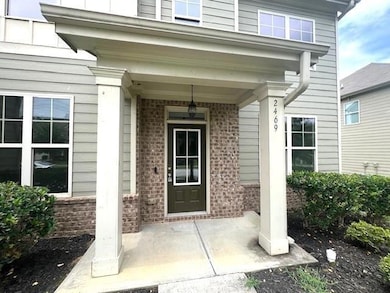 Entrance to property featuring brick siding and covered porch