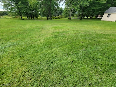 View of green lawn featuring view of wooded area